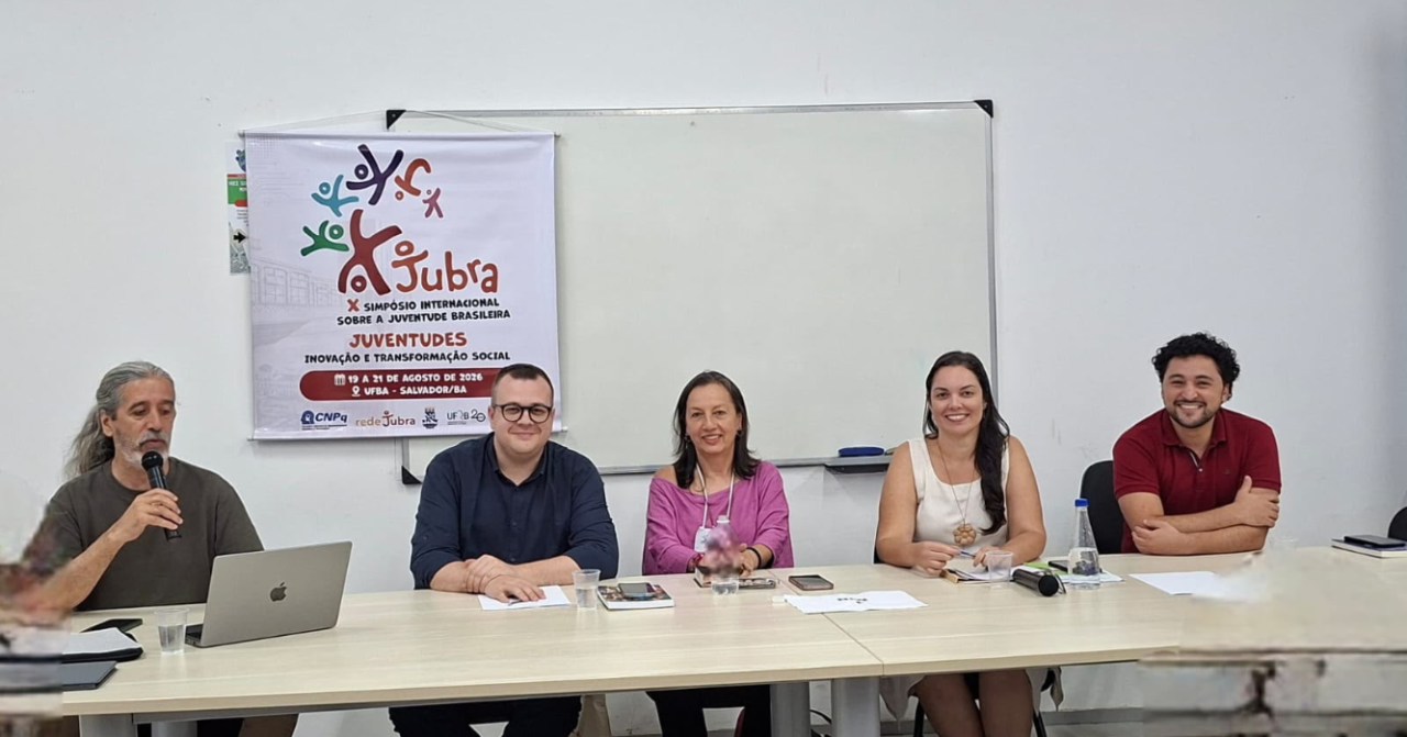 Mesa-redonda do X Simpósio Internacional sobre Juventudes Brasileiras (JUBRA), com cinco participantes reunidos em sala na UFBA, em Salvador (BA), durante a programação do evento.