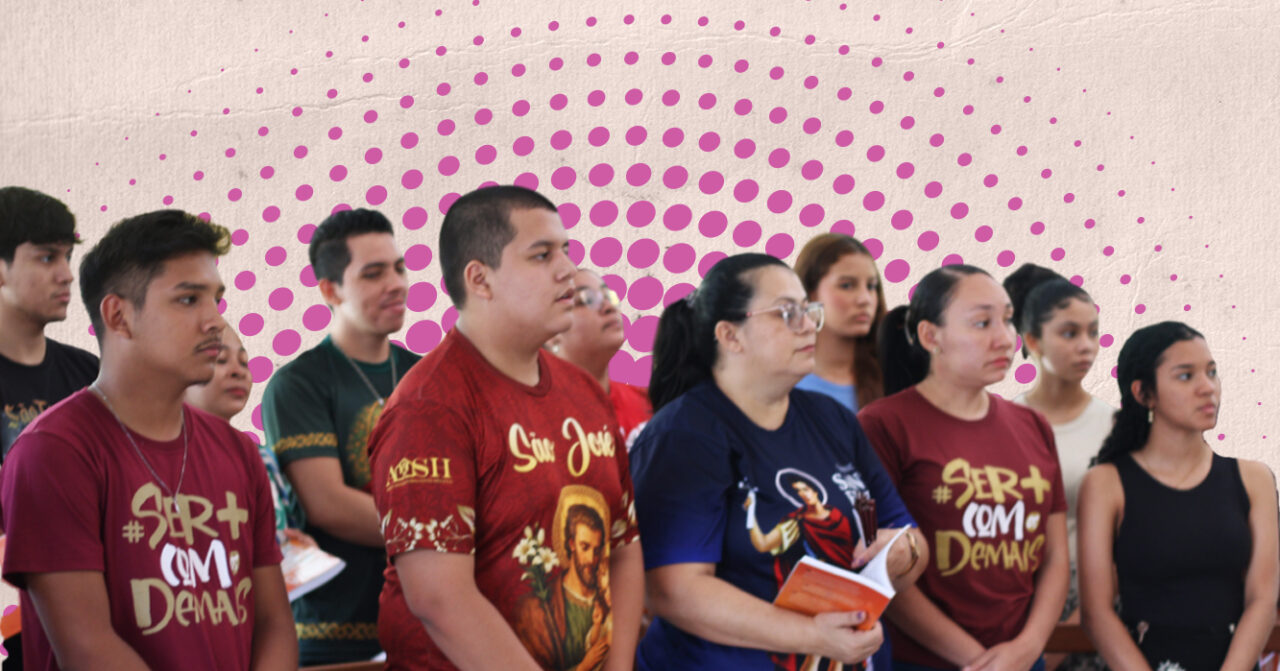 Grupo de jovens e adultos acompanha atentamente uma atividade formativa, reunido em ambiente comunitário, com destaque para camisetas religiosas e materiais de apoio nas mãos de alguns participantes.