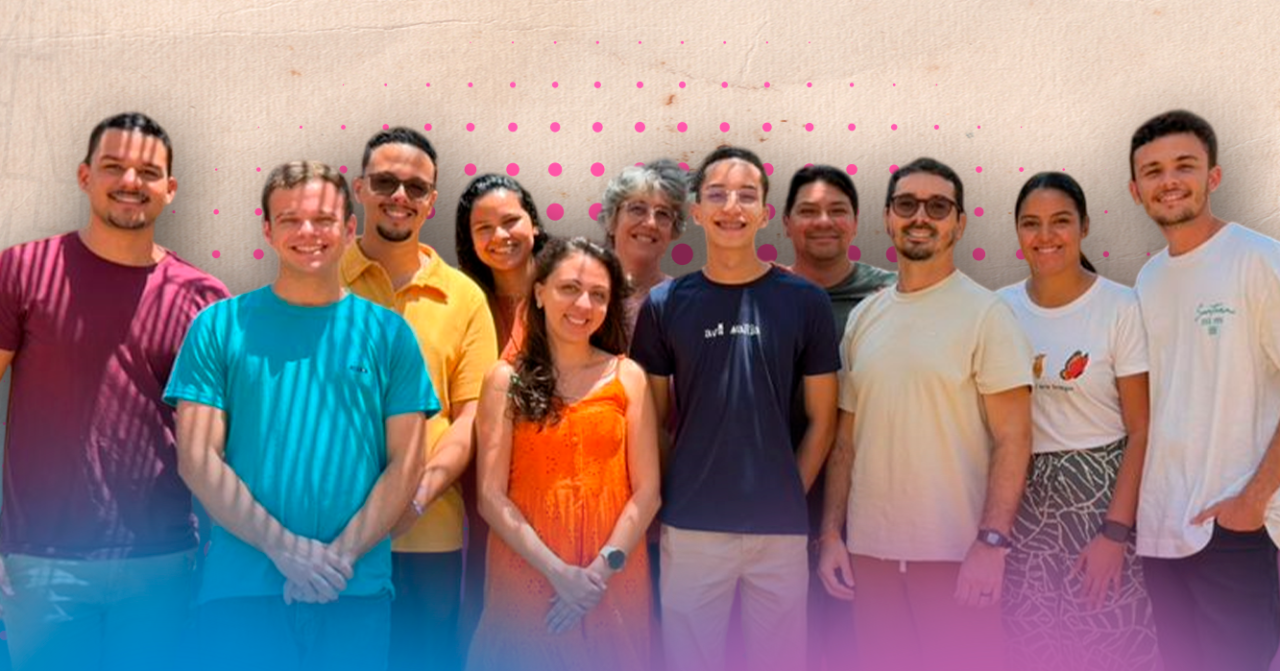 Grupo de 11 pessoas posa para foto coletiva diante de uma parede clara, em ambiente externo, com elementos gráficos em tons de rosa e azul sobrepostos à imagem.